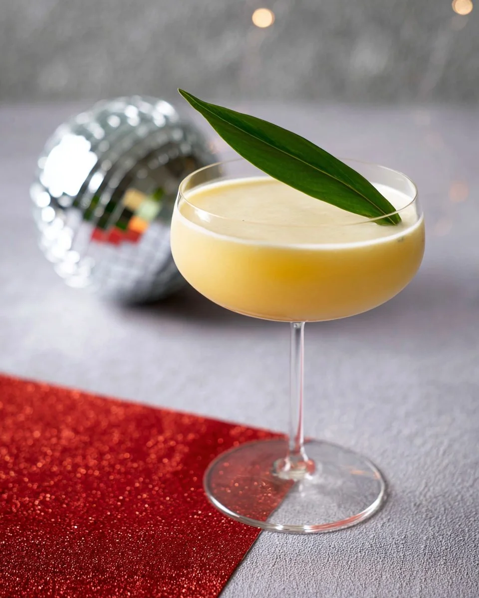 Thai Mango Sticky Rice Cocktail garnished with fresh mango and coconut.