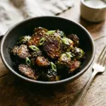 Plate of teriyaki glazed Brussels sprouts drizzled with sauce and garnished.